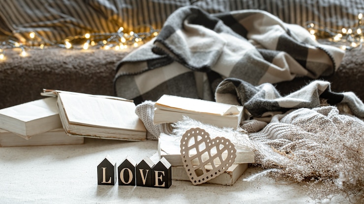 Kostenlose Foto stillleben mit dem dekorativen wort liebe, bücher und gemütliche dinge.