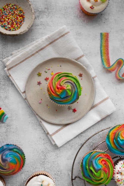 Kostenloses Foto stillleben mit regenbogen-cupcakes von oben