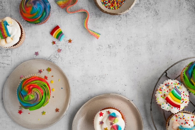 Kostenloses Foto stillleben mit regenbogen-cupcakes von oben