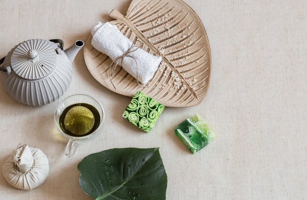 Stillleben mit Seife, Handtuch, Blatt und grünem Tee. Gesundheits- und Schönheitskonzept.