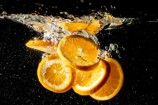 Stillleben Schuss von Orangenscheiben, die unter Wasser fallen und einen großen Spritzer machen