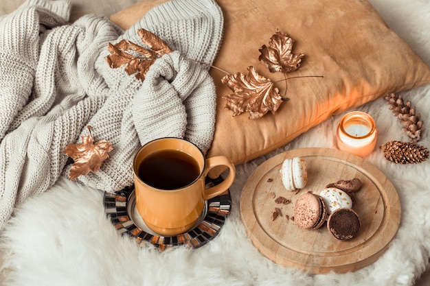 Stillleben Tasse Tee mit Herbstlaub und Pullover.