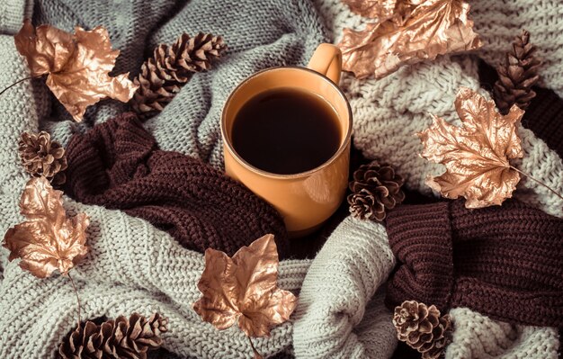 Stillleben Tasse Tee mit Herbstlaub und Pullover.