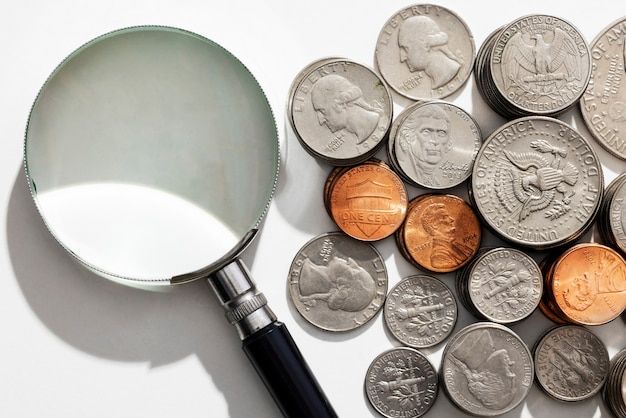 Kostenloses Foto stillleben von dollarmünzen mit lupe