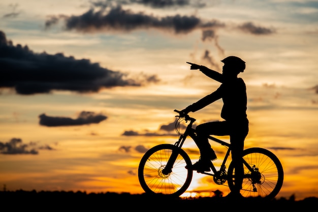 Stillstehendes Schattenbild des Radfahrers bei Sonnenuntergang. aktives Outdoor-Sportkonzept