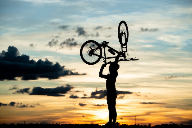 Stillstehendes Schattenbild des Radfahrers bei Sonnenuntergang. aktives Outdoor-Sportkonzept
