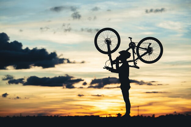 Stillstehendes Schattenbild des Radfahrers bei Sonnenuntergang. aktives Outdoor-Sportkonzept