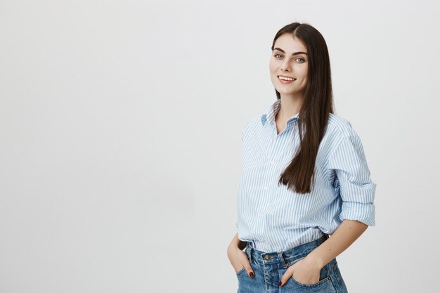 Stilvolle attraktive weibliche Büroangestellte in Hemd und Jeans