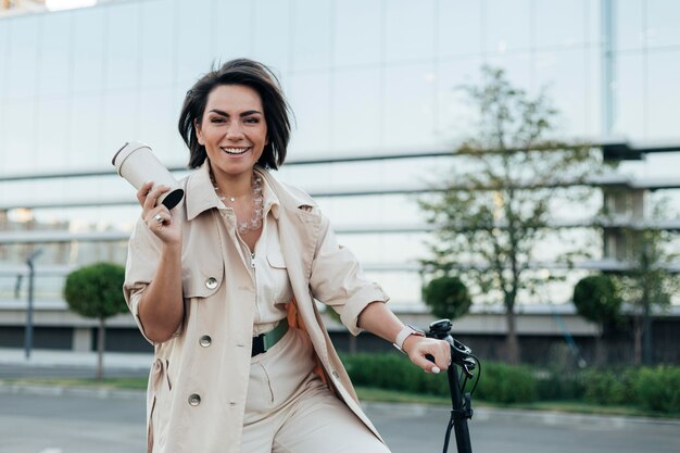 Stilvolle erwachsene Frau, die mit umweltfreundlichem Fahrrad aufwirft