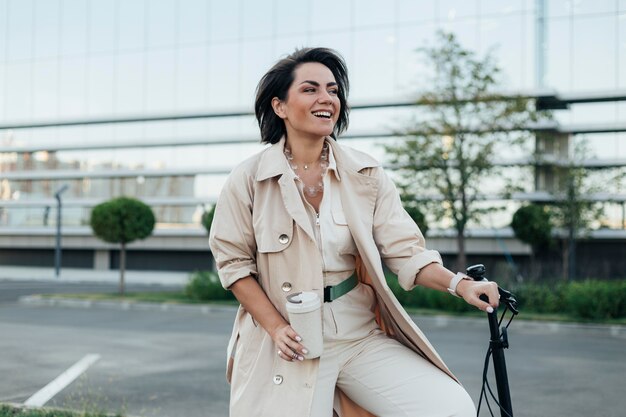 Stilvolle erwachsene Frau, die mit umweltfreundlichem Fahrrad aufwirft