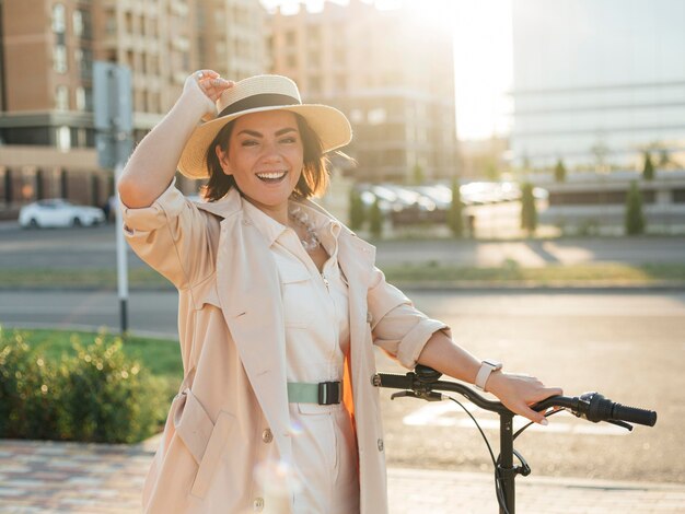 Stilvolle erwachsene Frau, die mit umweltfreundlichem Fahrrad aufwirft