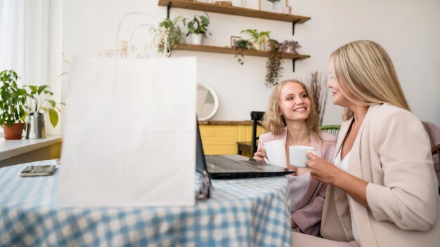 Stilvolle erwachsene Frauen, die online einkaufen