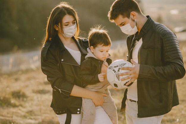 Stilvolle Familie, die auf einem sonnigen Feld geht