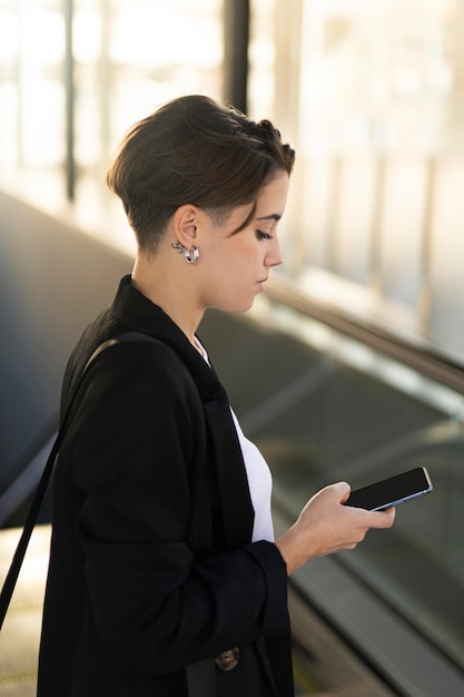 Kostenloses Foto stilvolle frau, die ihr telefon überprüft