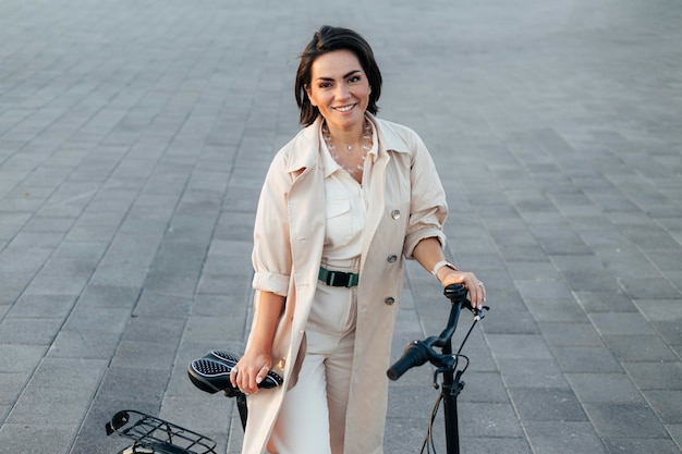 Kostenloses Foto stilvolle frau, die mit fahrrad draußen aufwirft