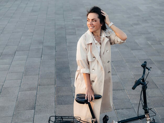 Stilvolle Frau, die mit Fahrrad draußen aufwirft