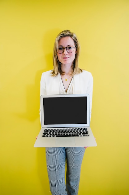 Stilvolle Frau, die modernen Laptop zeigt