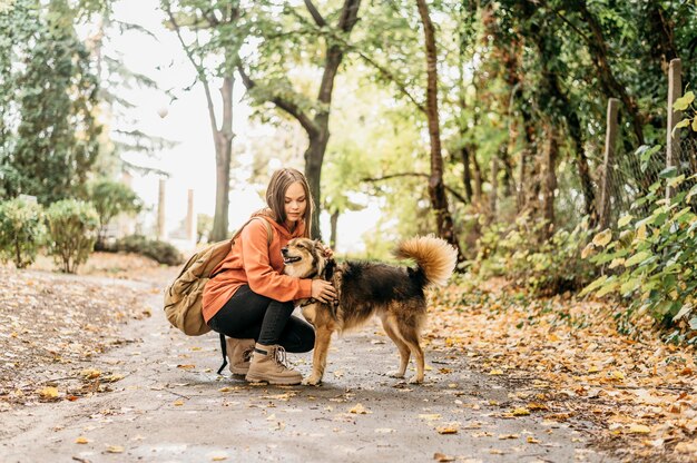 Stilvolle Frau für einen Spaziergang mit ihrem Hund