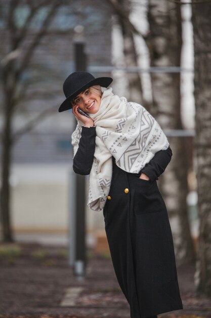 Stilvolle Frau mit Smartphone im Park