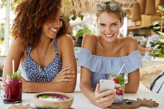 Stilvolle Freunde, die im Café sitzen