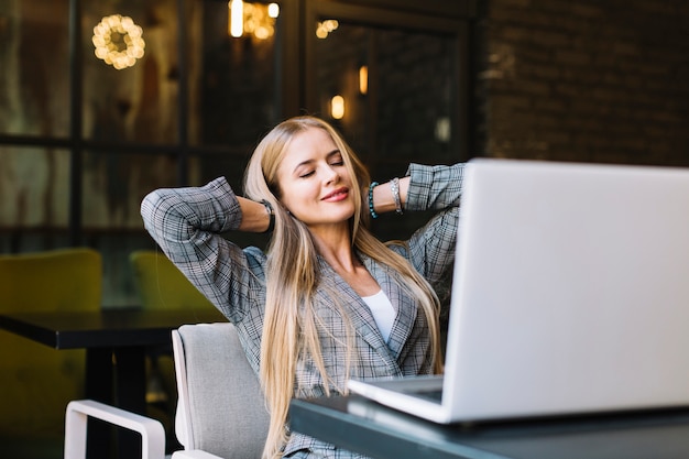 Stilvolle Geschäftsfrau mit Laptop in der gemütlichen Kaffeestube