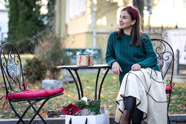 Stilvolle junge Frau auf einem Spaziergang nach dem Einkaufen der Weihnachtsvorbereitungen