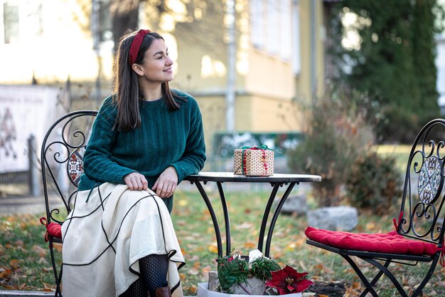 Stilvolle junge Frau auf einem Spaziergang nach dem Einkaufen der Weihnachtsvorbereitungen