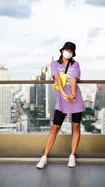 Stilvolle kaukasische Frau in der trendigen Neutasche Panama und Taille auf Dach in Bangkok.