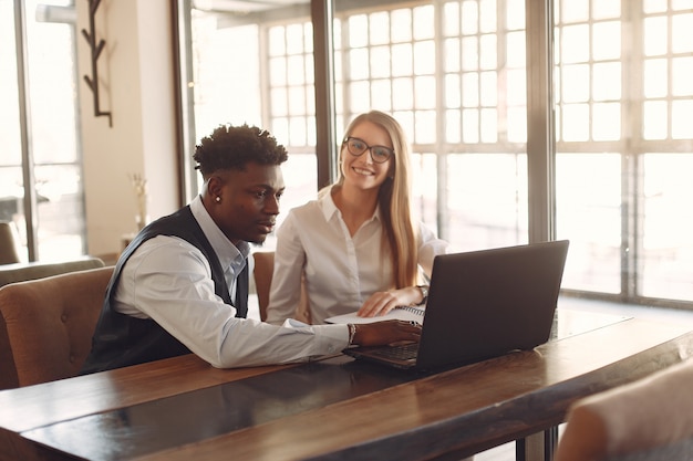 Stilvolle Leute, die in einem Büro arbeiten und den Laptop benutzen