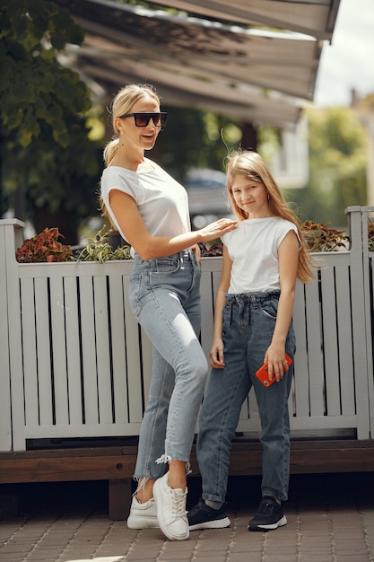 Stilvolle Mutter mit Tochter in einer Sommerstadt