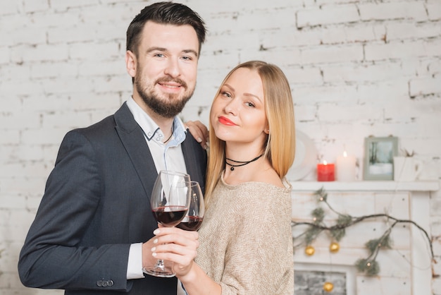 Kostenloses Foto stilvolle paare mit dem wein, der kamera betrachtet