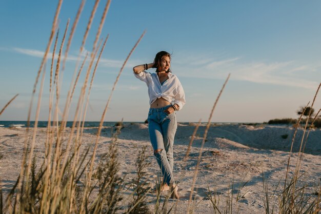 Stilvolle schöne Frau in den Sommerferien am Strand, böhmischer Stil, Jeans