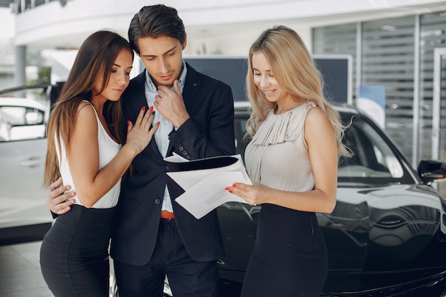 Stilvolle und elegante Leute in einem Autosalon