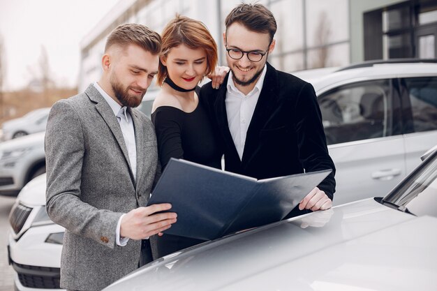 Stilvolle und elegante Paare in einem Autosalon