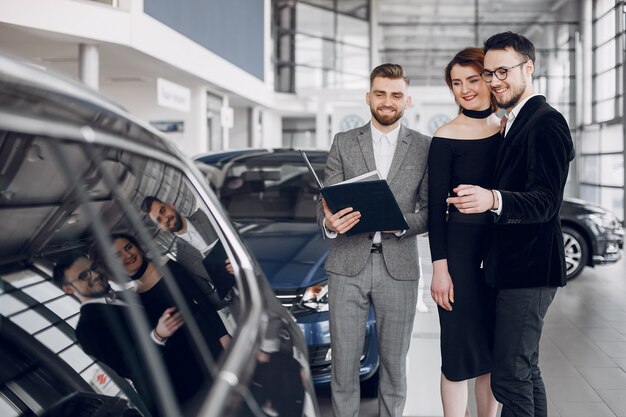 Stilvolle und elegante Paare in einem Autosalon