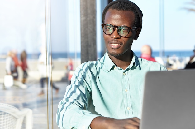 Stilvoller afroamerikanischer Mann mit Laptop