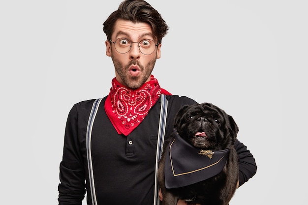 Stilvoller Brunetmann, der roten Bandana hält Hund hält