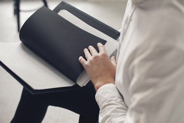 Stilvoller Geschäftsmann, der in einem Büro arbeitet und das Telefon benutzt