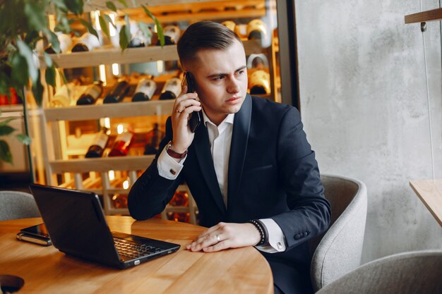 Stilvoller Geschäftsmann, der in einem Café arbeitet