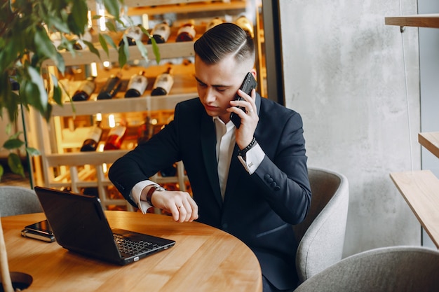 Stilvoller Geschäftsmann, der in einem Café arbeitet