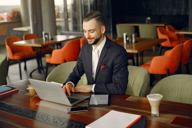 Stilvoller Geschäftsmann, der in einem Café arbeitet