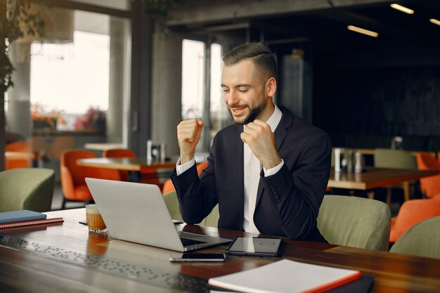 Stilvoller Geschäftsmann, der in einem Café arbeitet