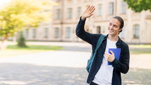 Stilvoller junger Mann, der glücklich ist, wieder an der Universität zu sein