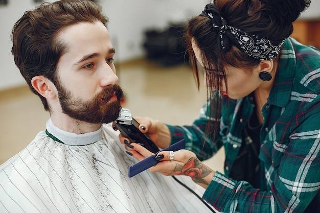 Stilvoller Mann, der in einem Friseursalon sitzt