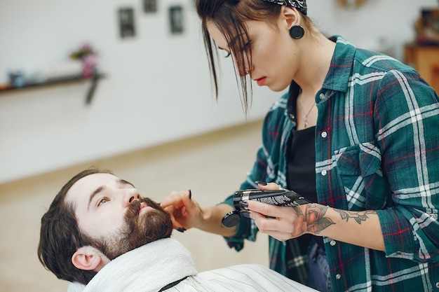 Stilvoller Mann, der in einem Friseursalon sitzt