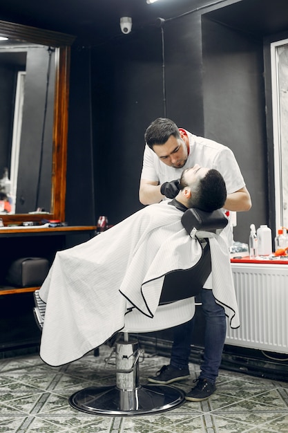 Stilvoller Mann, der in einem Friseursalon sitzt