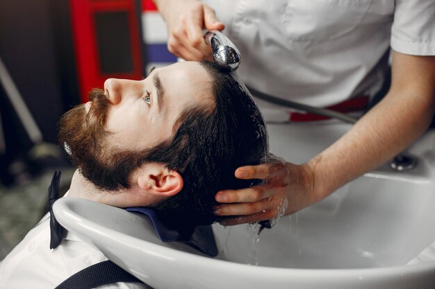 Stilvoller Mann, der in einem Friseursalon sitzt