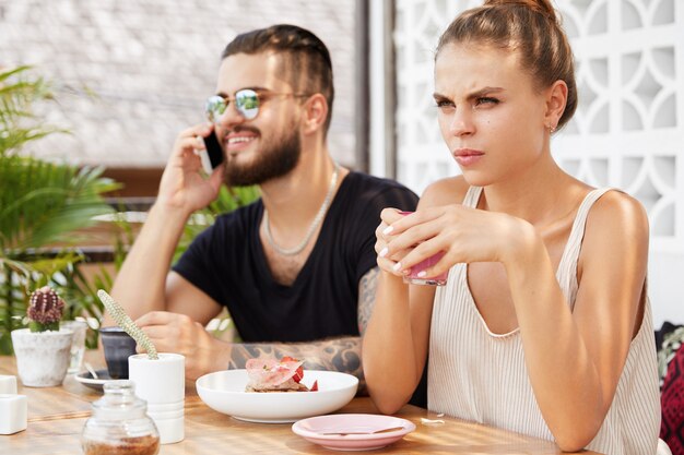 Stilvoller Mann und Frau, die im Café sitzen