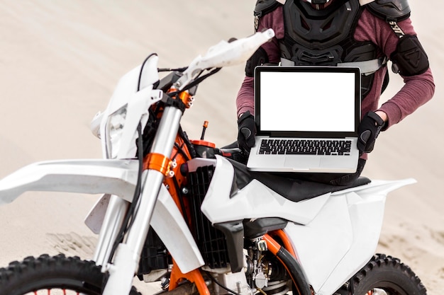 Kostenloses Foto stilvoller motorradfahrer, der laptop hält