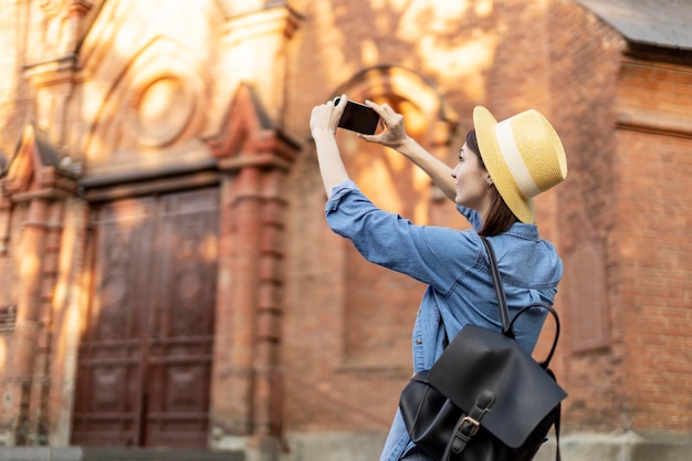 Kostenloses Foto stilvoller tourist mit hut, der bilder im urlaub macht